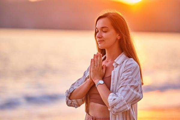 woman praying breathing sea sunset